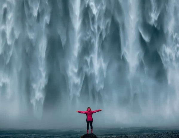 Woman standing in front of a waterfall